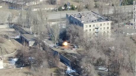 Dieser Screenshot aus Drohnenaufnahmen zeigt ein Militärfahrzeug, das Schüsse in der Nähe eines Gebäudes abfeuert.