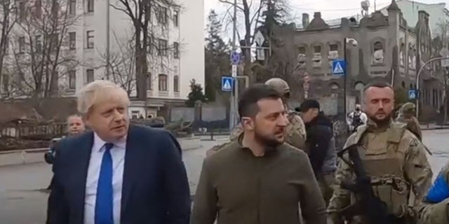 Auf der linken Seite gehen der Premierminister des Vereinigten Königreichs und der ukrainische Präsident Volodymyr Selenskyj durch die Straßen von Kiew. 