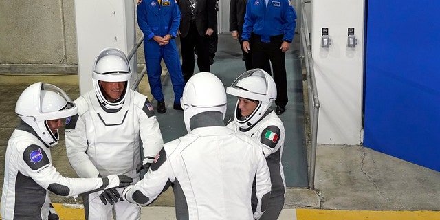 Astronauten der SpaceX Crew-4, links, Missionsspezialistin Jessica Watkins, Pilot Bob Hines, Kommandant Kjell Lindgren und Missionsspezialistin ESA-Astronautin Samantha Cristoforetti aus Italien versammeln sich, nachdem sie das Betriebsgebäude und den Antrieb für einen Flug zum Startkomplex verlassen haben. Ein Mittwoch, der 27. April 2022, im Kennedy Space Center in Cape Canaveral, Florida.