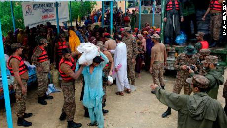 Armeekräfte verteilen am 24. August in einem Hilfslager im Distrikt Jamshoro im Süden Pakistans Lebensmittel und Hilfsgüter an Vertriebene.