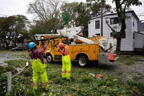 Arbeiter heben umgestürzte Drähte, damit Maschinen am Samstag umgestürzte Bäume in Halifax erreichen können.