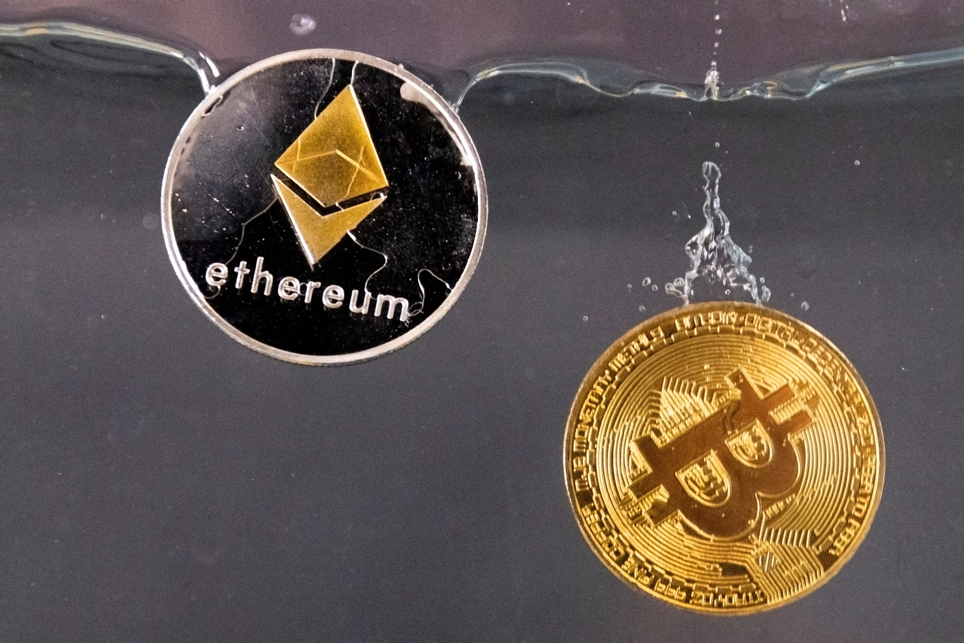 Gedenkmünzen von Bitcoin und Ether versinken im Wasser
