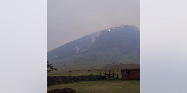 Rauch steigt von einem Feuer auf, das am 6. Oktober 2022 im Vulkangebiet Rano Raraco auf der Osterinsel, Chile, brennt, in diesem Bild, das aus sozialen Medien stammt. 